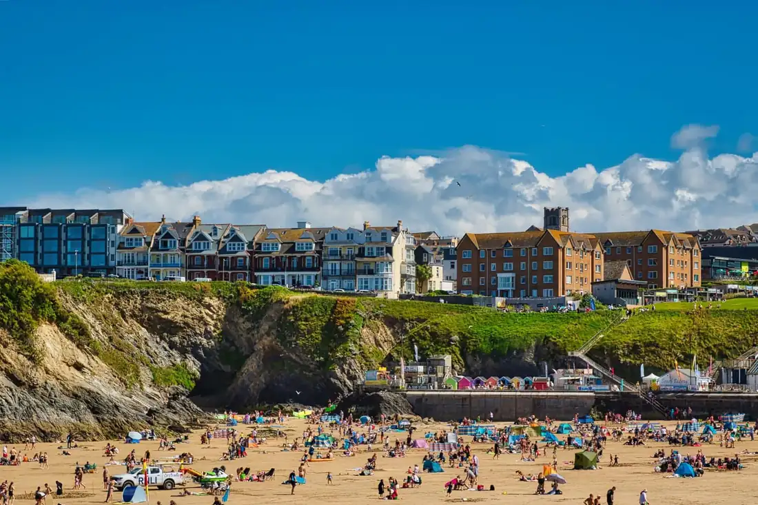 A packed British seaside beach under clear blue skies on a hot summer day during the UK's sunniest year on record