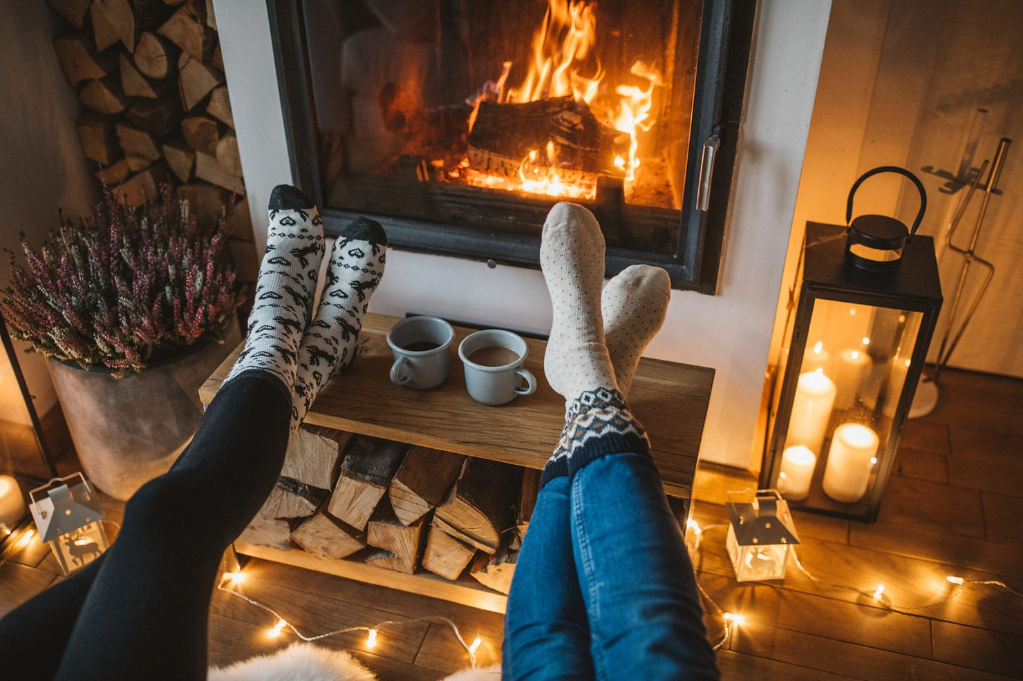 Two pairs of feet warming in front of a fire