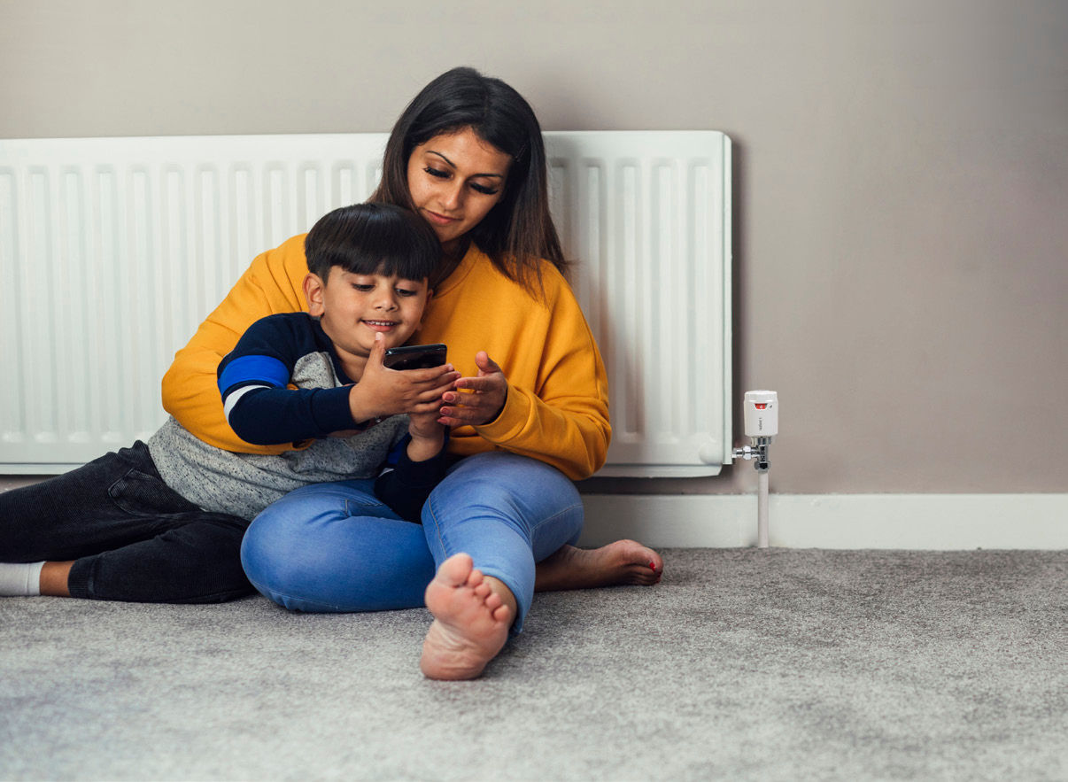 Mother and child warming themselves on a radiator